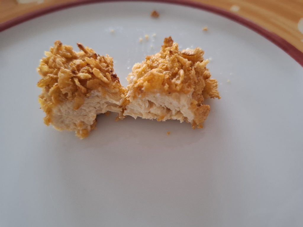 nugget de pollo rebozado con corn-flakes ya cocinado y partido a la mitad